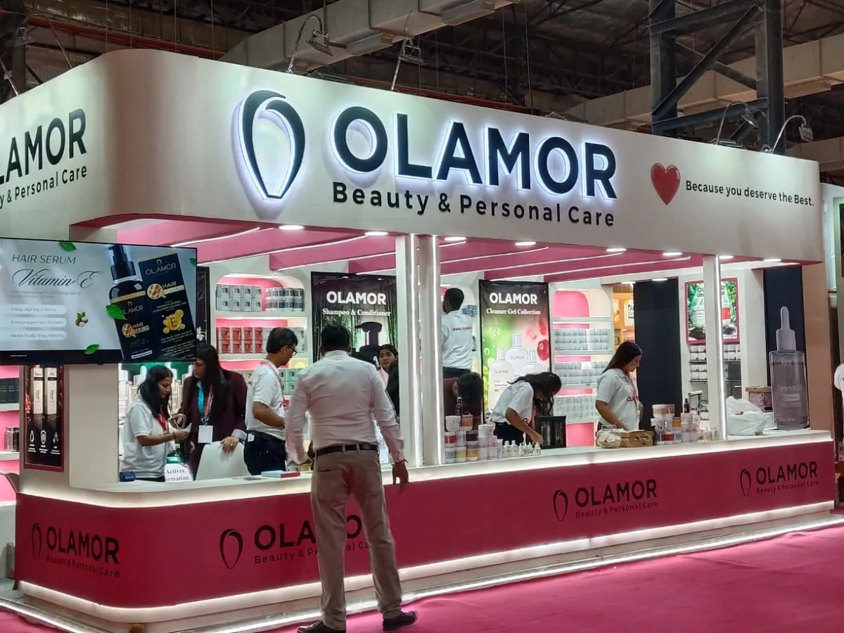 Olamor beauty exhibition stall with pink shelving and long sales counter